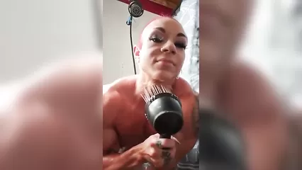 Накаченная женщина принимает душ